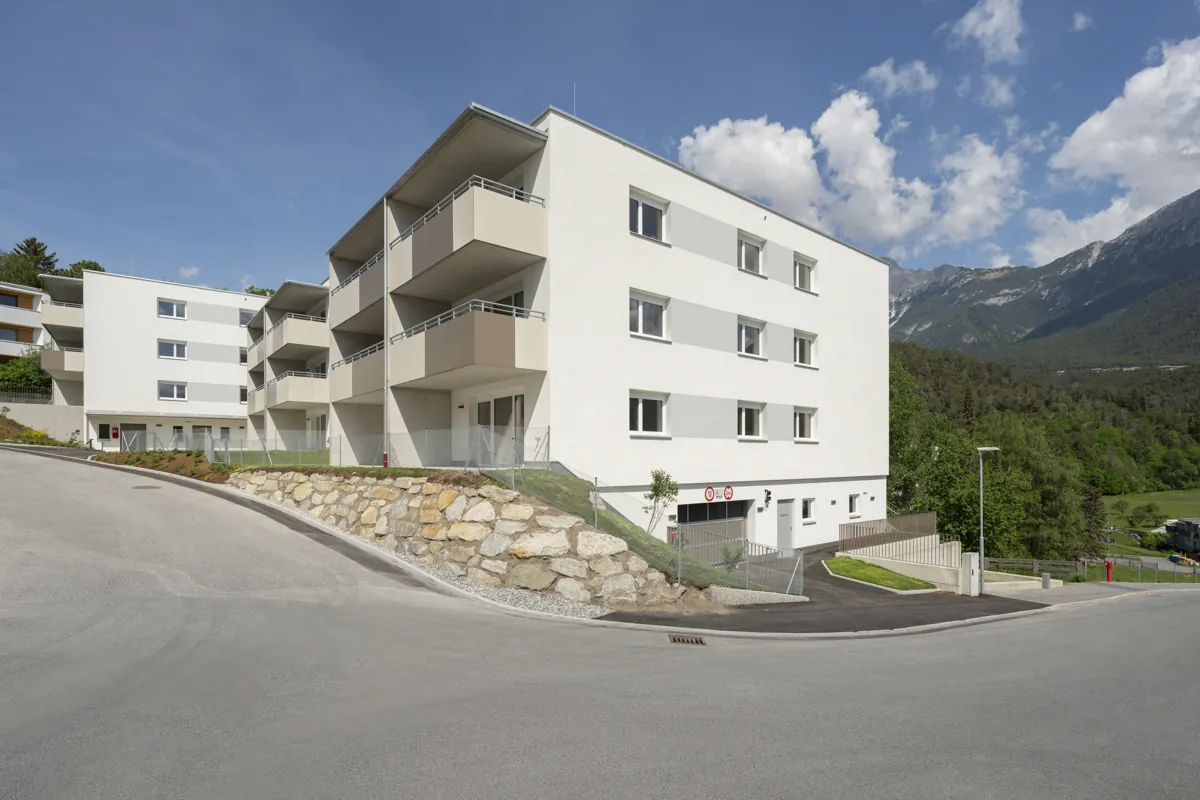 Helle Wohnhäuser am Pfarrersbichl Nord in Telfs vor Tiroler Bergen